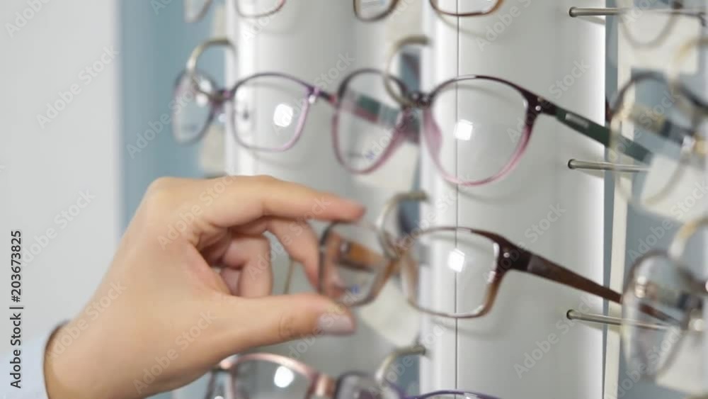 Close Up Shot Of Woman Choosing New Eyeglasses In Optical Shop