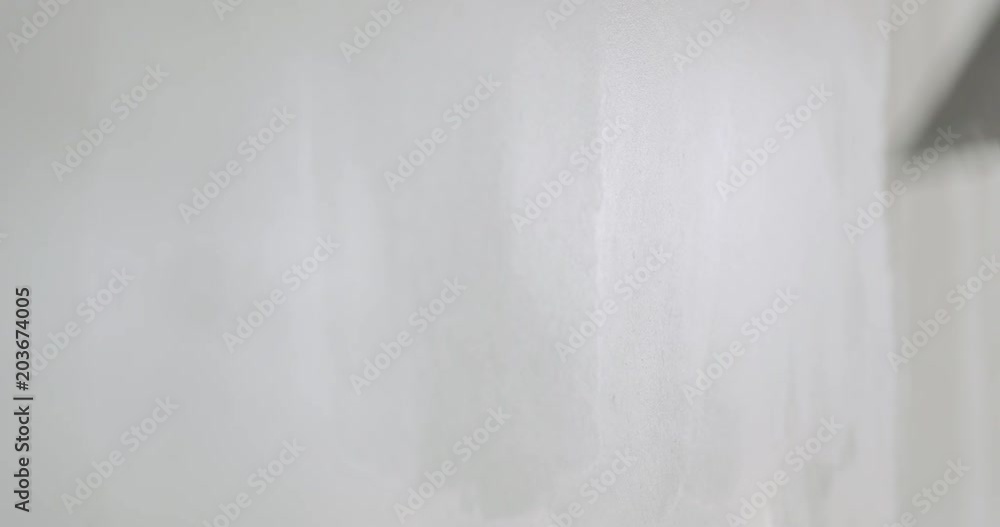 Slow motion handheld shot of worker applying putty on the wall Slow motion handheld shot of worker applying putty on the wall