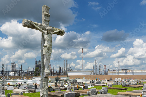 View of the Holy Rosary Cemetery in Taft, Louisiana, with a petrochemical plant on the background. The cemetery is located in the so called 'Cancer Alley'. photo