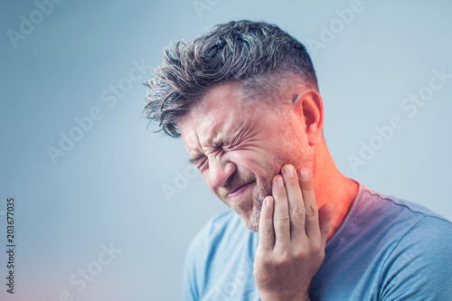 Toothache, medicine, health care concept, Teeth Problem, young man suffering from tooth pain, caries photo