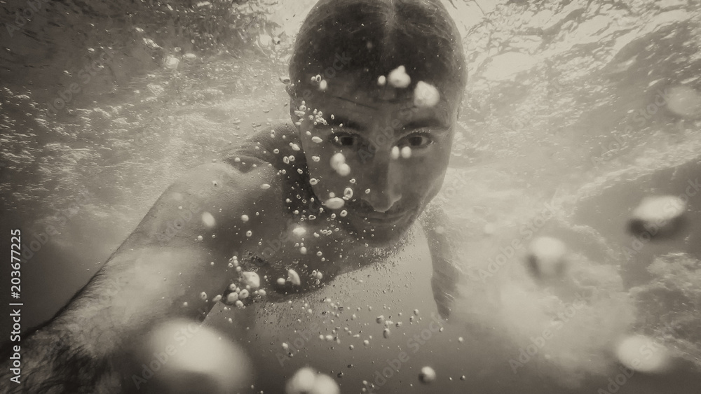 Fototapeta premium Man swimming under water