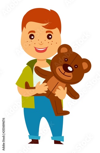 Redhead boy with freckles holds soft teddy bear