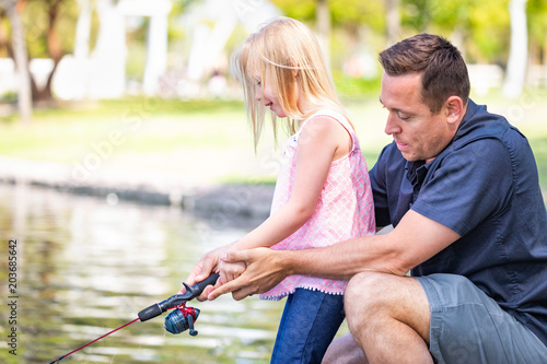 Young Caucasian Father and Daughter Having Fun Fishing At The Lake