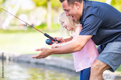 Young Caucasian Father and Daughter Having Fun Fishing At The Lake