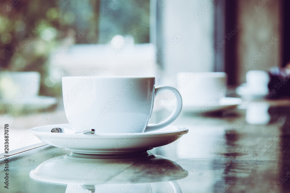 White Coffee Cup placing on table near window with bokeh from outside White Coffee Cup placing on table near window with bokeh from outside