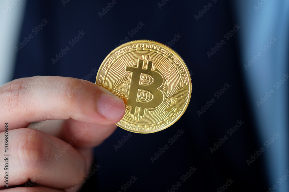 Businessman hand holding bitcoins, cryptocurrency and blockchain concept Businessman hand holding bitcoins, cryptocurrency and blockchain concept