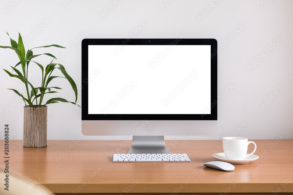 All in one computer, mouse, keyboard, coffee cup and plant vase on wooden table All in one computer, mouse, keyboard, coffee cup and plant vase on wooden table
