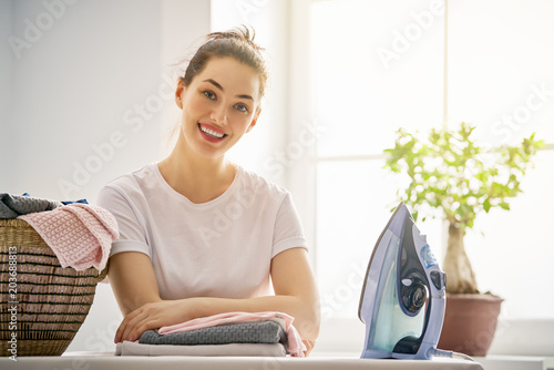 Photo woman is ironing at home