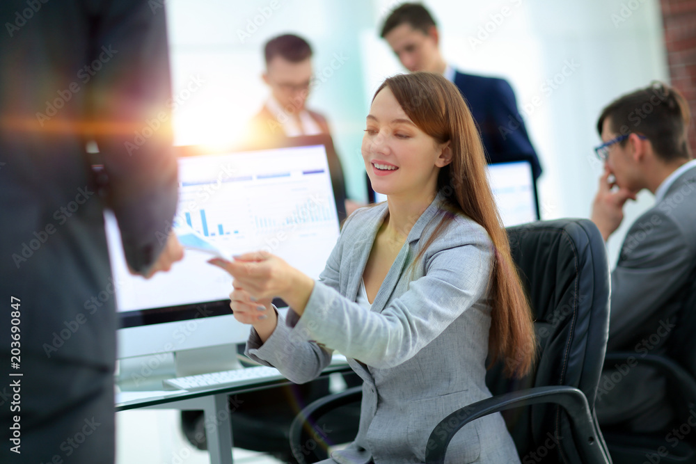 young beautiful woman examines graphics sitting at her workplace young beautiful woman examines graphics sitting at her workplace