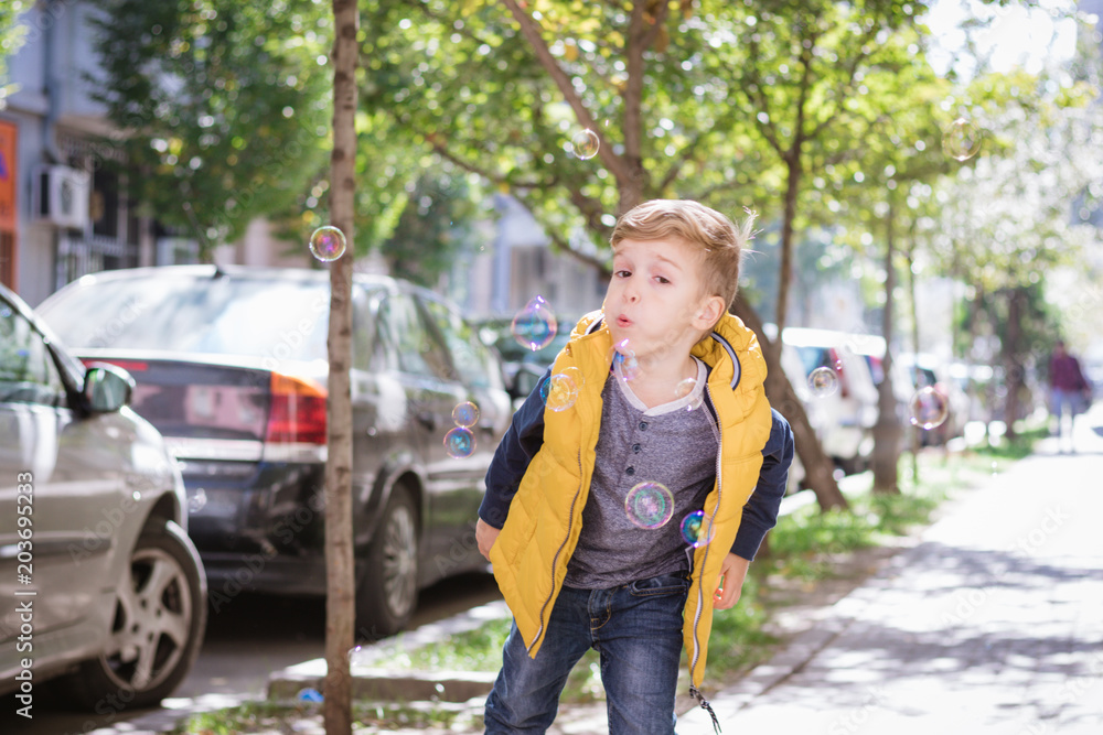 Small boy having fun with soap bubbles outdoors. Small boy having fun with soap bubbles outdoors.