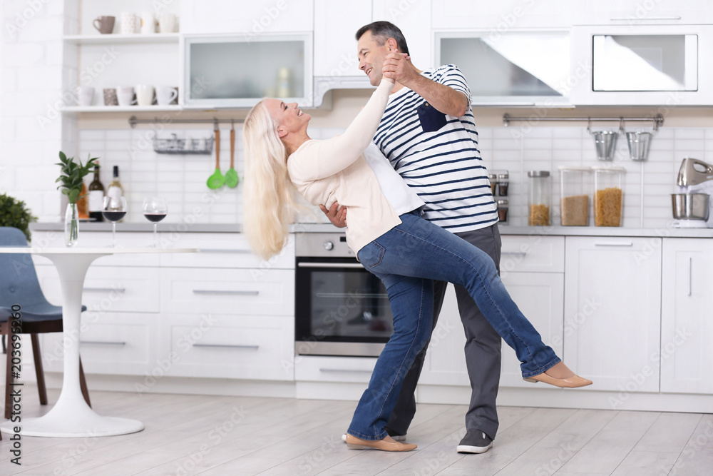 Happy mature couple dancing in kitchen Happy mature couple dancing in kitchen