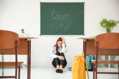 Upset teenage girl sitting ...