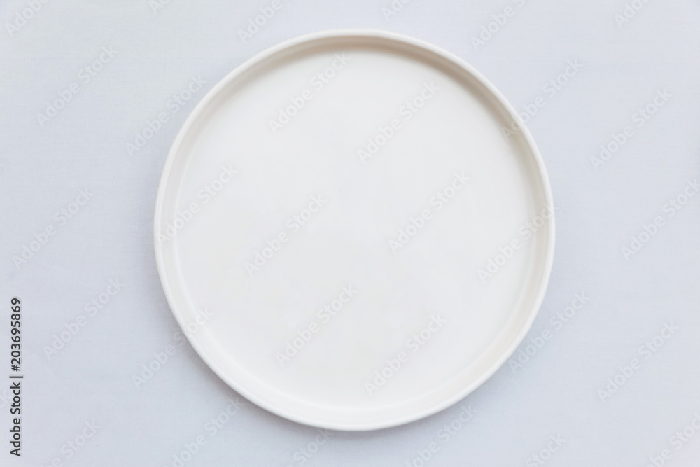 Top view of white empty plate on white tablecloth. - obrazy, fototapety, plakaty 