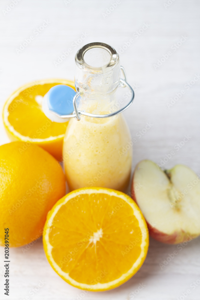 orange-apple smoothies and fruits on a white background close-up. orange-apple smoothies and fruits on a white background close-up.