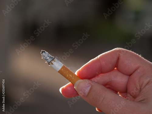 Woman hand holding a cigarette almost finished