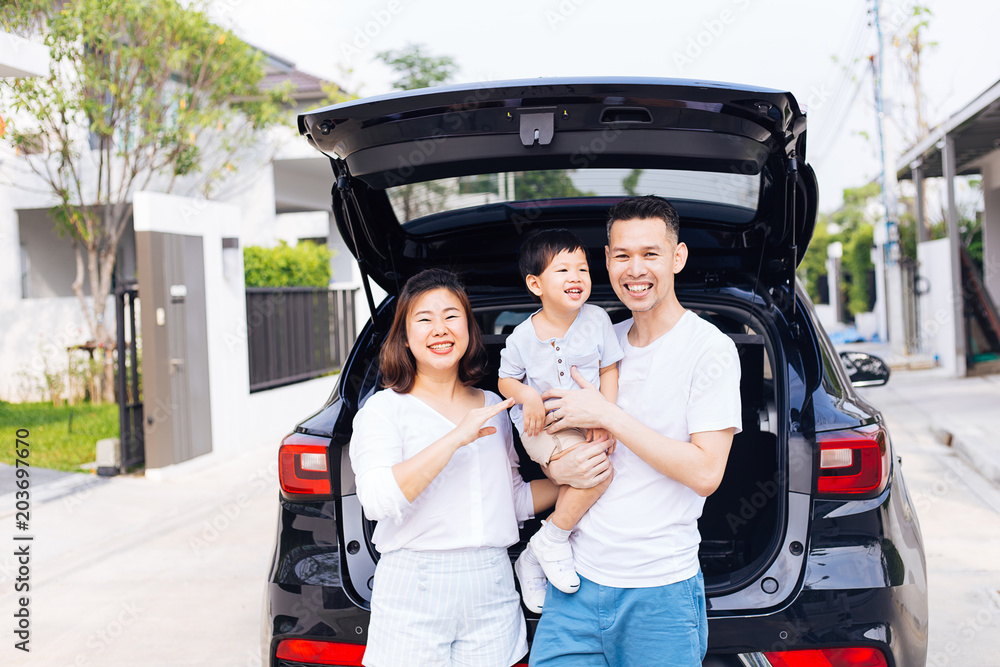 Happy Asian family standing on the back of SUV car with smile and happiness