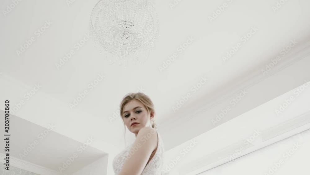 Beautiful bride in a gorgeous dress and bridal veil stands by the window dreaming, smiling charmingly. Happy moments, couple goals, morning of a bride Beautiful bride in a gorgeous dress and bridal veil stands by the window dreaming, smiling charmingly. Happy moments, couple goals, morning of a bride