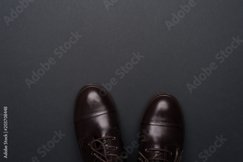 Dark brown man shoes on grey background. Flat lay, top view