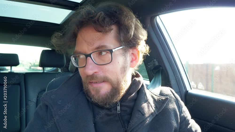 Man unhappy talking on speakerphone in car driving Man unhappy talking on speakerphone in car driving