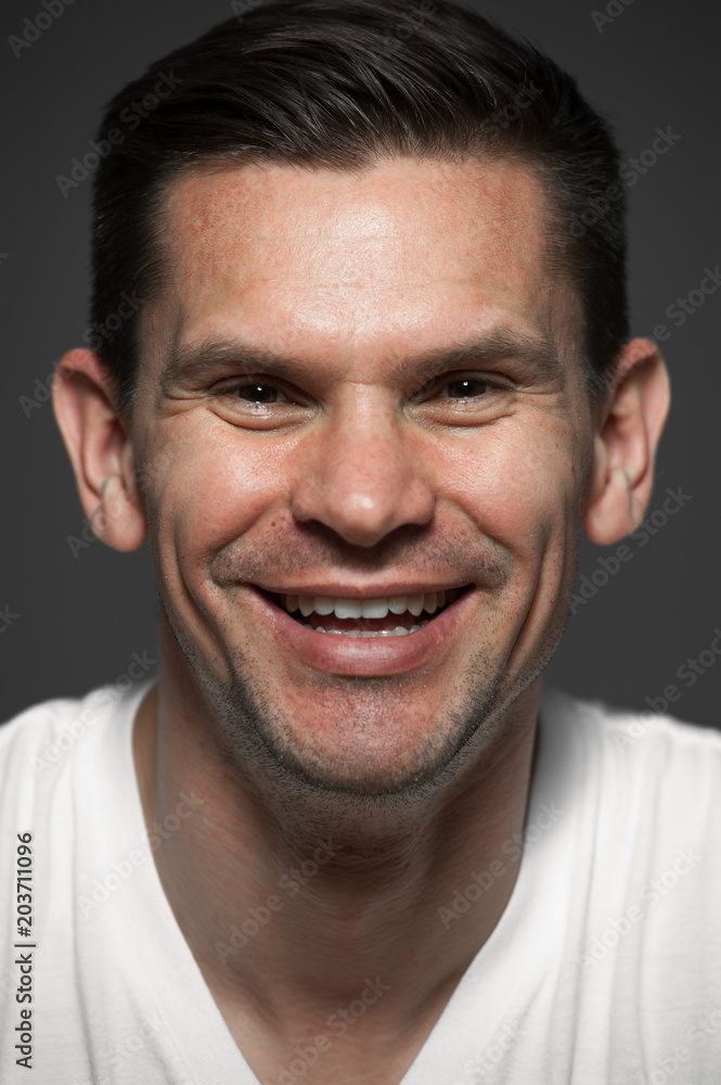 Close-up portrait of positive laughing caucasian man on gray background Close-up portrait of positive laughing caucasian man on gray background