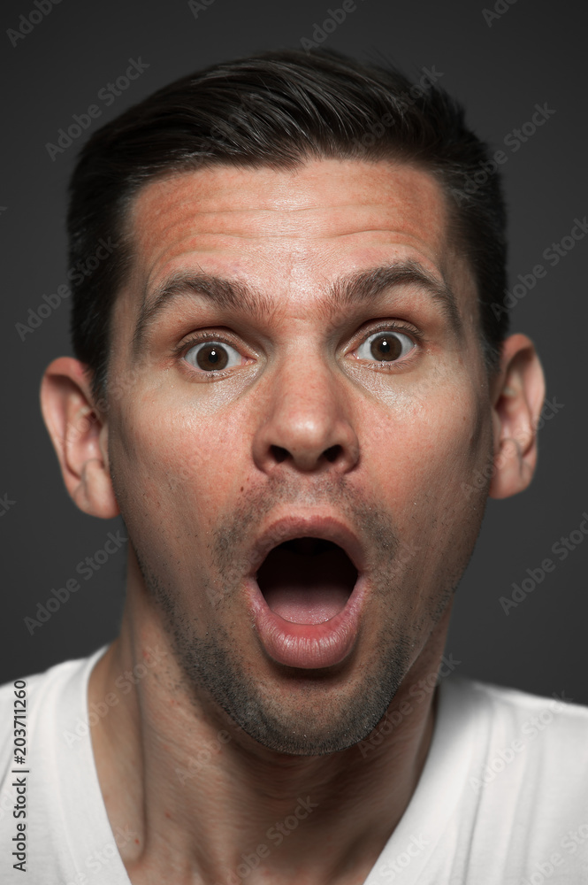Close-up portrait of surprised caucasian man on gray background