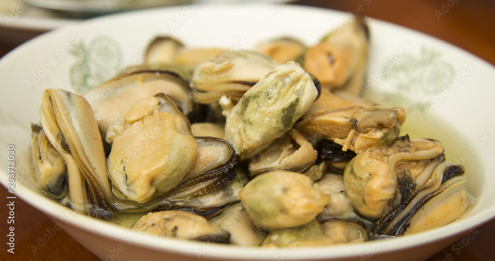 Tasty oiled pickled mussels iin a plate on the table Tasty oiled pickled mussels iin a plate on the table