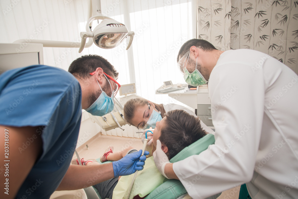 Boy with perfect teeth at the dentist doing check up with the clinic at the background - oral hygiene health care concept