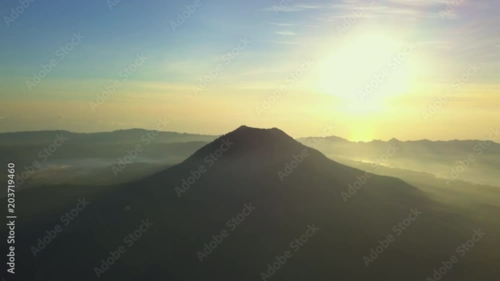 View of silhouette top of volcano Batur foggy morning sunrise drone footage