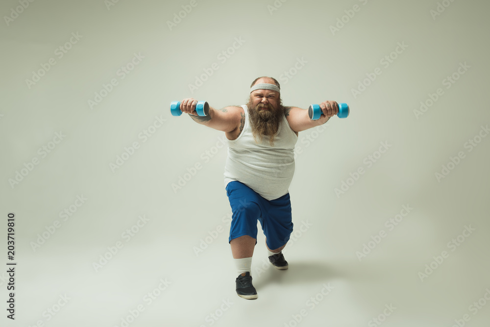Man with beard exercising with dumbbells Man with beard exercising with dumbbells