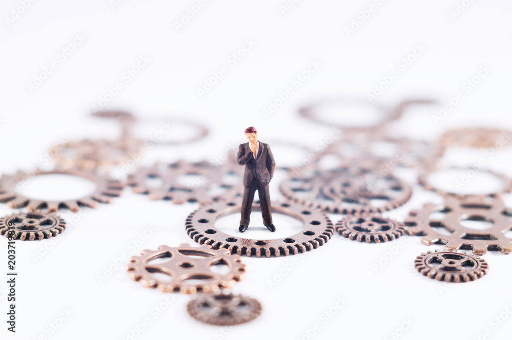 Conceptual photo of gears and a toy person. Business, law or political concept, which could represent decision making, leadership and so on. Conceptual photo of gears and a toy person. Business, law or political concept, which could represent decision making, leadership and so on.