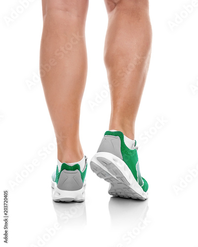 Male legs in sneakers over white.