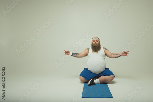 Fototapeta Naklejka Na Ścianę i Meble -  Man meditating on a yoga mat