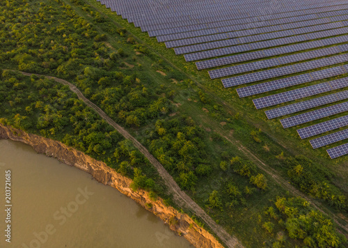 Photovoltaic solar panels for renewable energy, near a river.