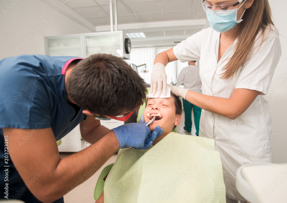 Boy with perfect teeth at the dentist doing check up with the clinic at the background - oral hygiene health care concept Boy with perfect teeth at the dentist doing check up with the clinic at the background - oral hygiene health care concept