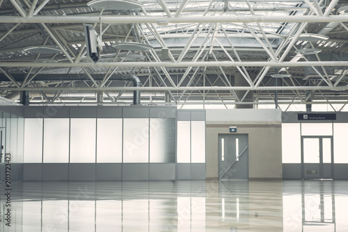 Wide light hall with grey door and concrete floor. Warehouse concept
