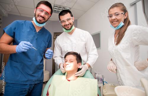Boy with perfect teeth at the dentist doing check up with the clinic at the background - oral hygiene health care concept