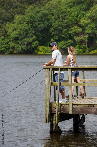 Man enjoying a beautiful day on the lake fishing for bass , Looking forward to a cold beer & fish & chips photo