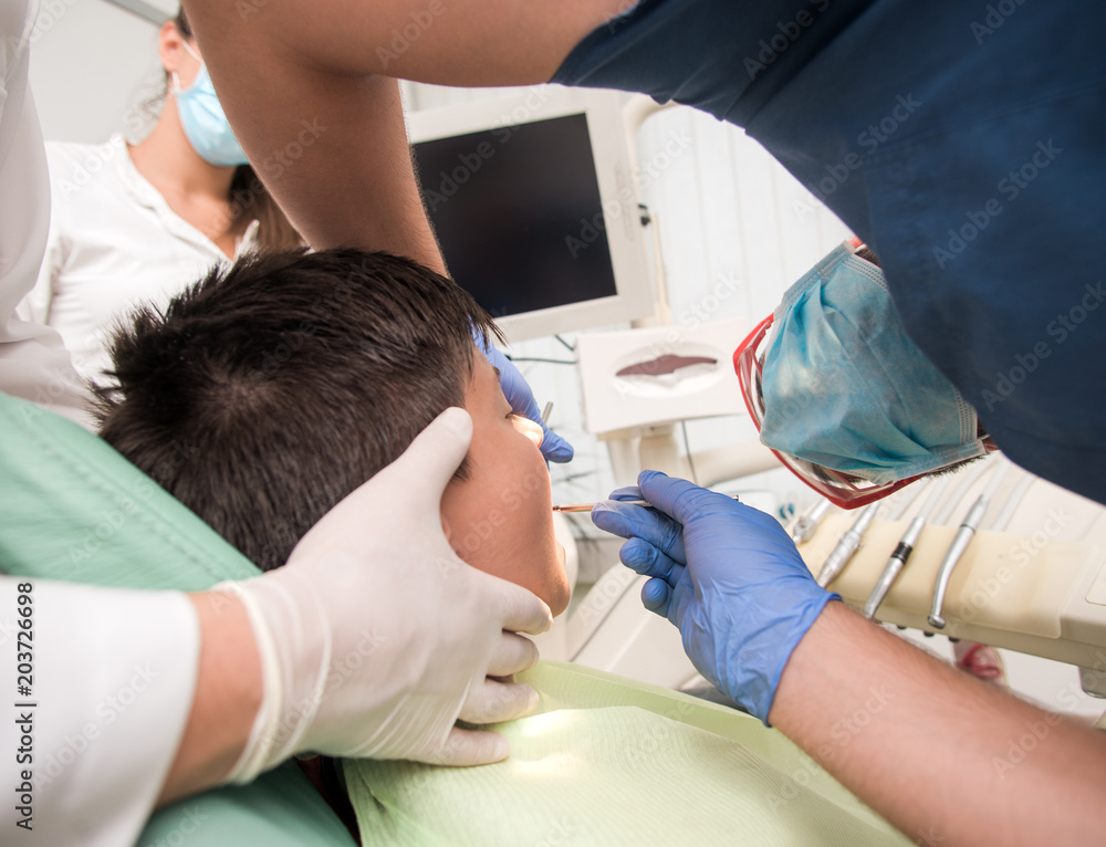 Boy with perfect teeth at the dentist doing check up with the clinic at the background - oral hygiene health care concept Boy with perfect teeth at the dentist doing check up with the clinic at the background - oral hygiene health care concept