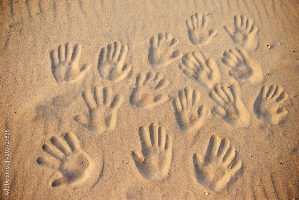 lots of hand prints on the sand
