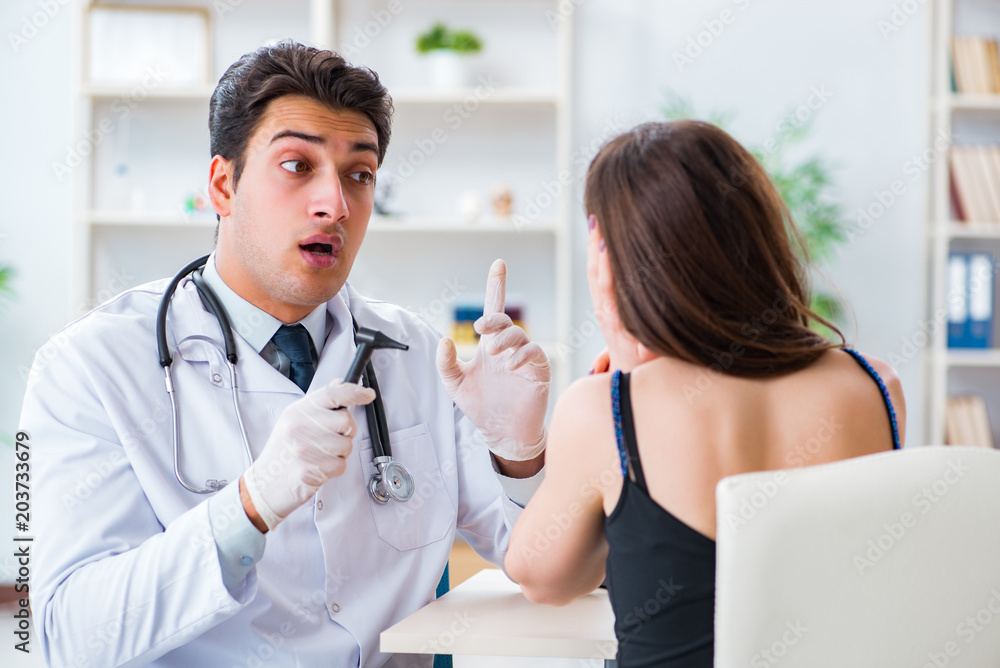 Doctor checking patients ear during medical examination Doctor checking patients ear during medical examination