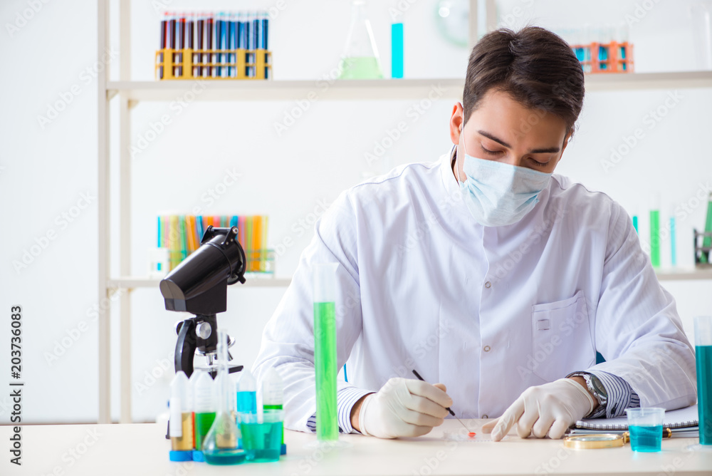 Young chemist student working in lab on chemicals Young chemist student working in lab on chemicals