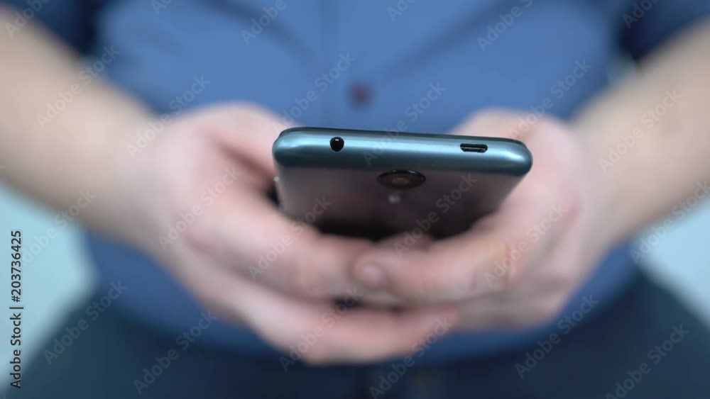 Male hands typing message on smartphone close up, searching for diet application Male hands typing message on smartphone close up, searching for diet application