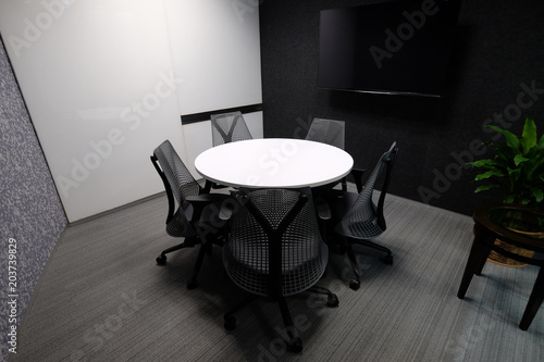 Small meeting room for five people with whiteboard and television accessory