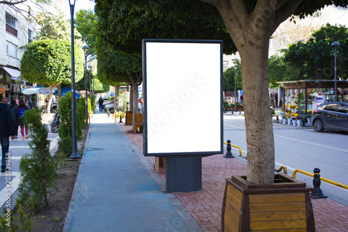 фотографія Blank vertical street billboard stand with city background.