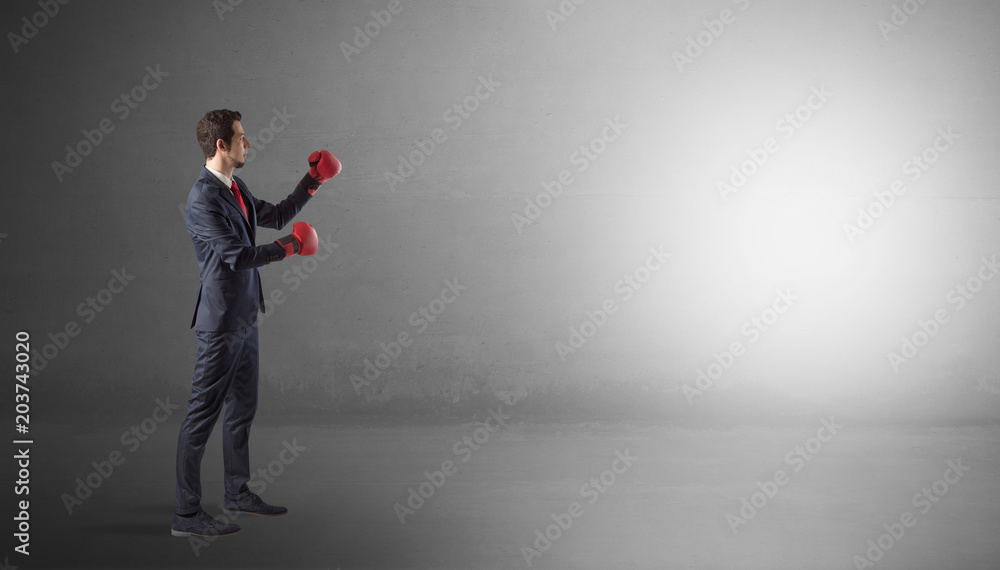 Businessman fighting with boxing gloves in an empty space
Businessman fighting with boxing gloves in an empty space