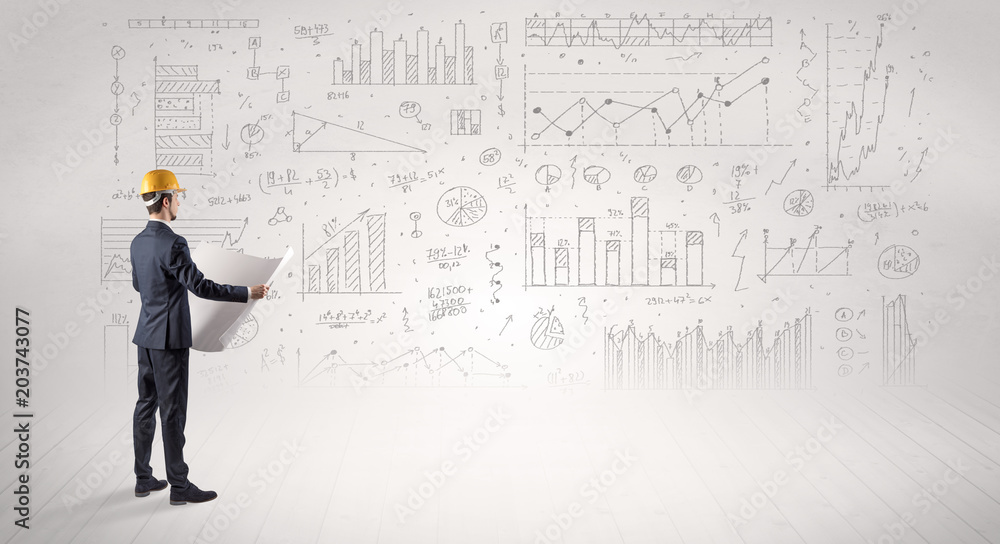 Engineer with construction helmet holding a plan and standing with graphs, charts and reports on the background Engineer with construction helmet holding a plan and standing with graphs, charts and reports on the background