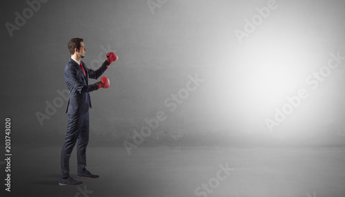 Businessman fighting with boxing gloves in an empty space  © ra2 studio