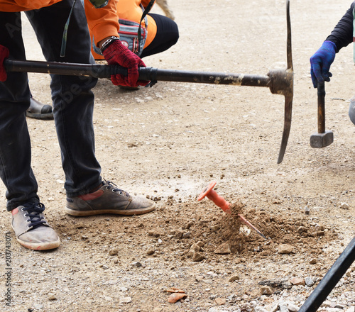 The workers are pinning and digging the ground on road construction , Thailand 