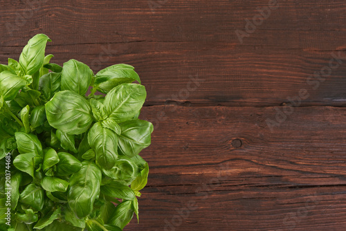 Basil leaves on wooden rustick background.