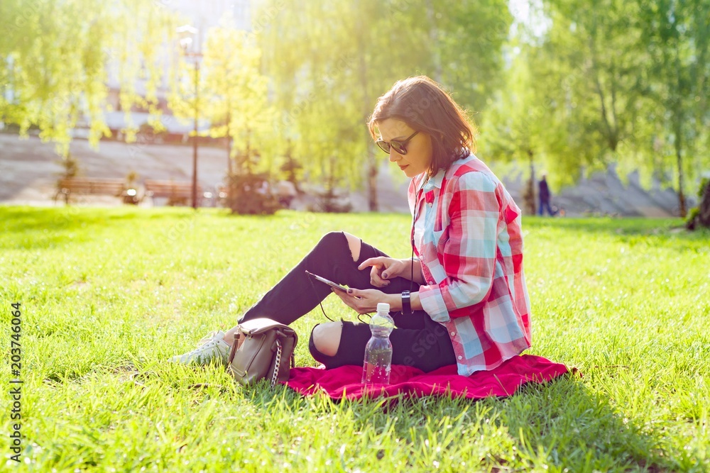 Adult middle-aged woman sits in city park Adult middle-aged woman sits in city park